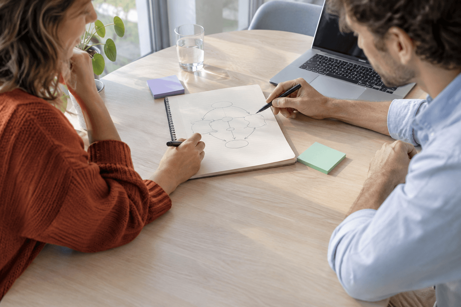 Sfeerbeeld: twee mensen werken samen een proces uit aan een bureau.